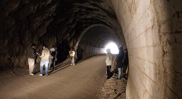 Los turistas ingresan al tunel caminando.